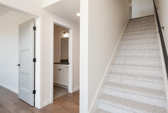 stairway with baseboards and wood finished floors