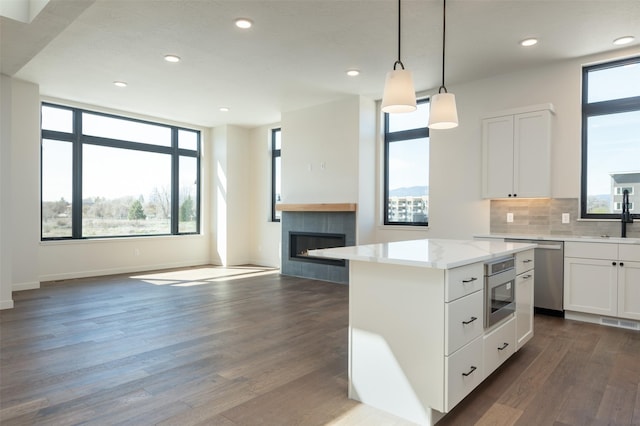 kitchen featuring dark wood-style floors, decorative backsplash, open floor plan, white cabinets, and oven