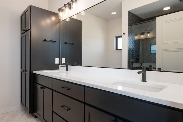 bathroom featuring marble finish floor, double vanity, a sink, and a shower stall