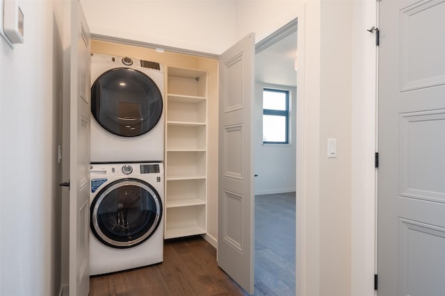 laundry area with stacked washing maching and dryer, laundry area, and dark wood finished floors