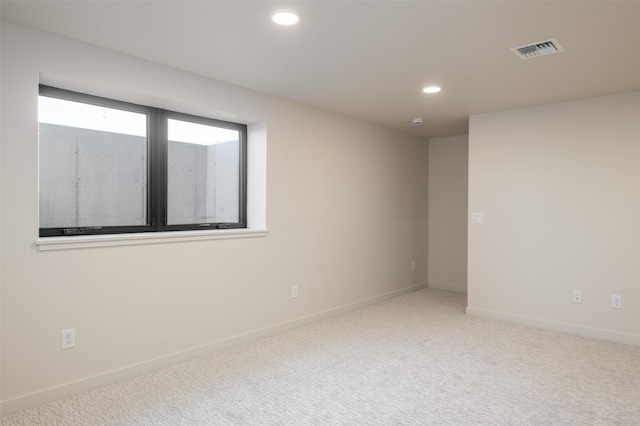 carpeted empty room with baseboards, visible vents, and recessed lighting