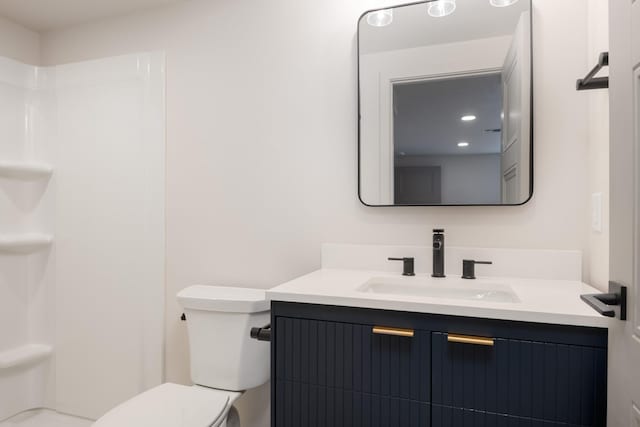 full bath featuring toilet, a shower, and vanity