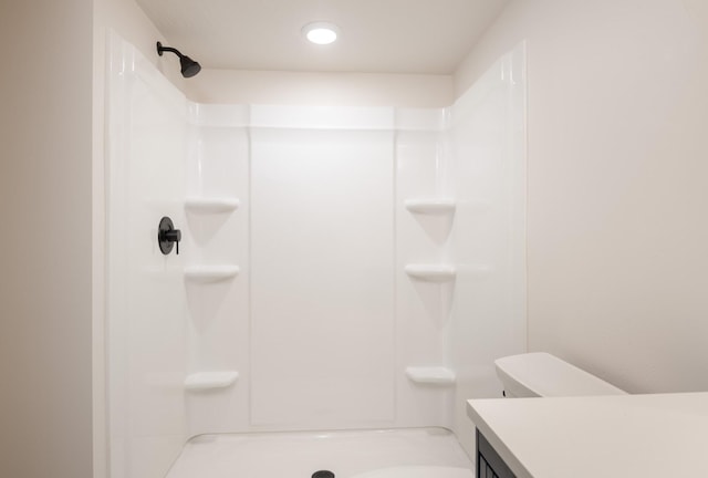 bathroom with a shower, vanity, and toilet