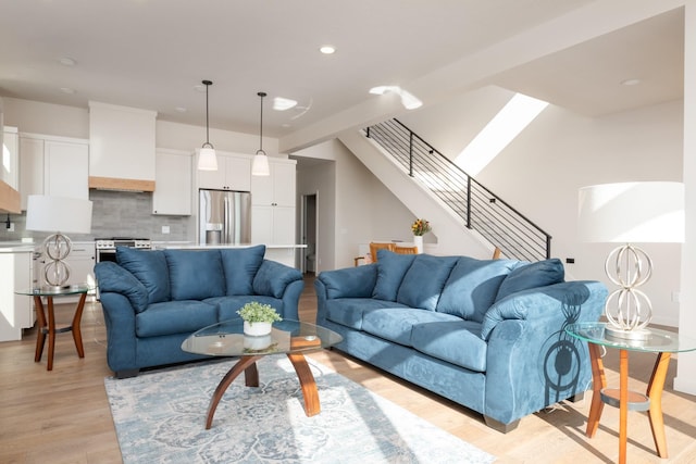 living area with recessed lighting, stairway, and light wood finished floors