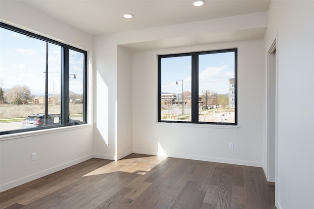 spare room with recessed lighting, baseboards, and wood finished floors