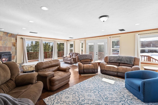 living area featuring plenty of natural light, crown molding, wood finished floors, and french doors