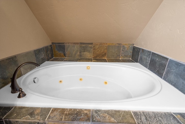 full bathroom featuring vaulted ceiling and a tub with jets