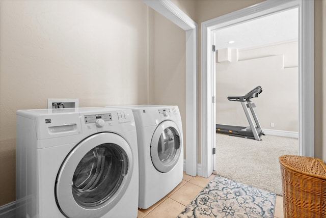 washroom featuring laundry area, baseboards, light colored carpet, separate washer and dryer, and light tile patterned flooring