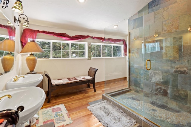 bathroom featuring a stall shower, recessed lighting, a sink, and wood finished floors