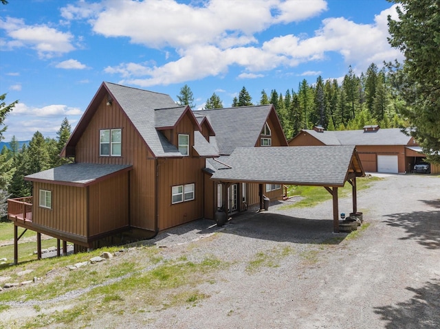 view of front of home featuring a shingled roof and gravel driveway