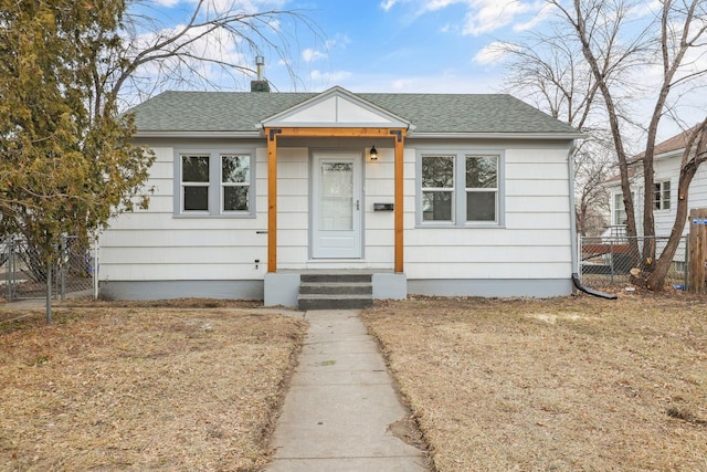 bungalow-style house featuring entry steps, a shingled roof, and fence