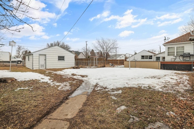 yard covered in snow featuring an outbuilding and fence