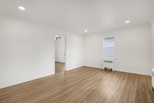 unfurnished room with radiator, baseboards, wood finished floors, and recessed lighting