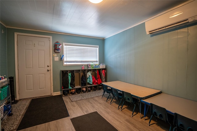 entryway featuring an AC wall unit, crown molding, and wood finished floors