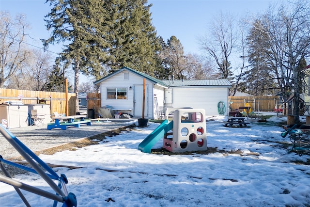 exterior space with a fire pit, metal roof, an outdoor structure, and fence