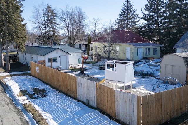 view of yard featuring an outbuilding, a shed, a fenced backyard, and a residential view