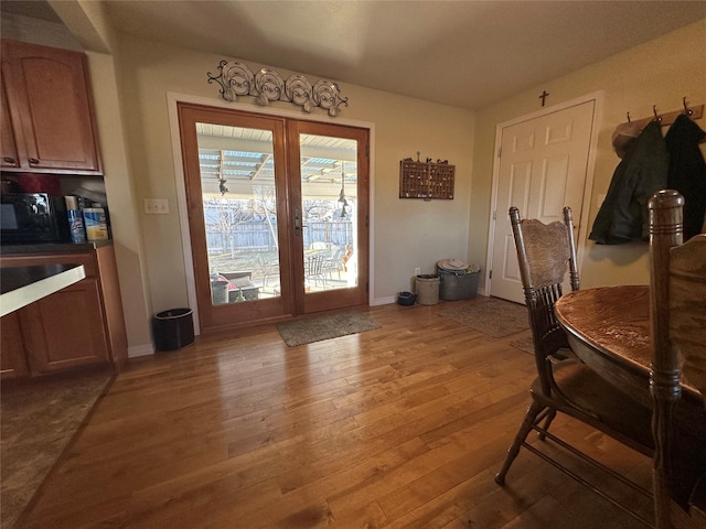 doorway to outside featuring light wood-style flooring and baseboards