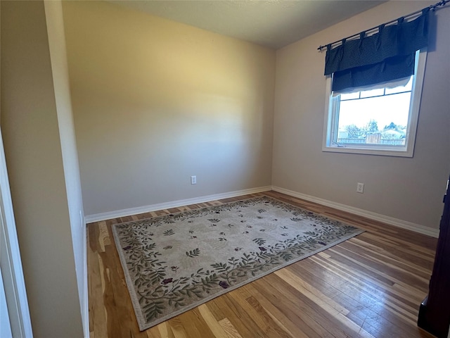 empty room with baseboards and wood finished floors