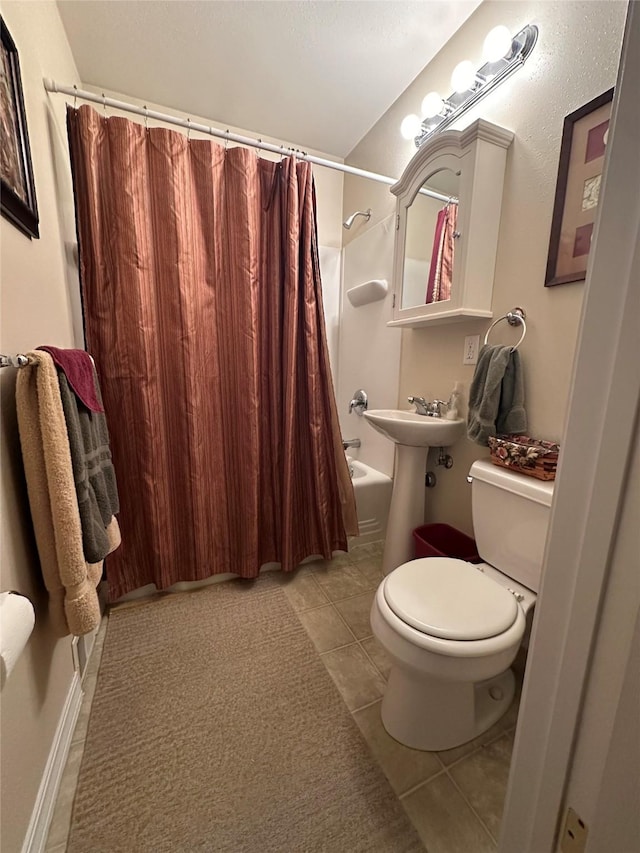 bathroom with toilet, shower / bath combo, a sink, and tile patterned floors