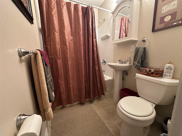 bathroom with shower / tub combo with curtain, a sink, toilet, and tile patterned floors