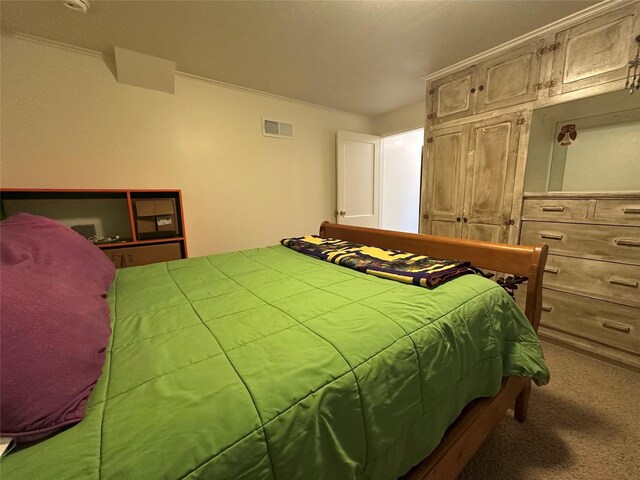 carpeted bedroom featuring visible vents and crown molding