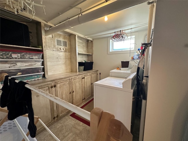 laundry room with washing machine and dryer, cabinet space, and visible vents