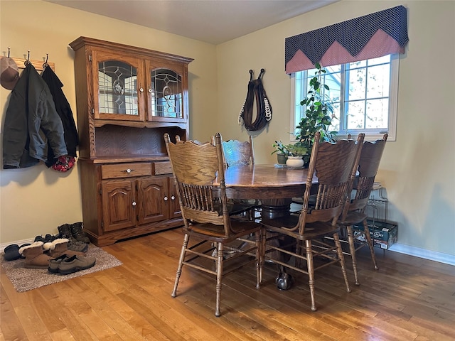 dining space featuring light wood-type flooring and baseboards