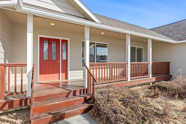 property entrance featuring covered porch and roof with shingles