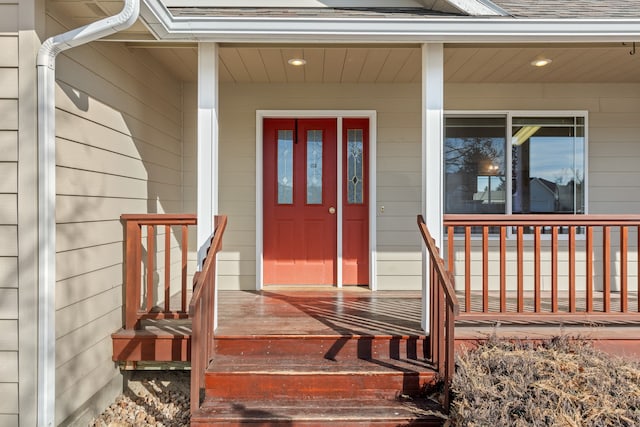 property entrance with covered porch and roof with shingles