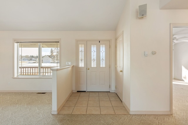 entryway featuring light carpet, visible vents, baseboards, lofted ceiling, and light tile patterned flooring