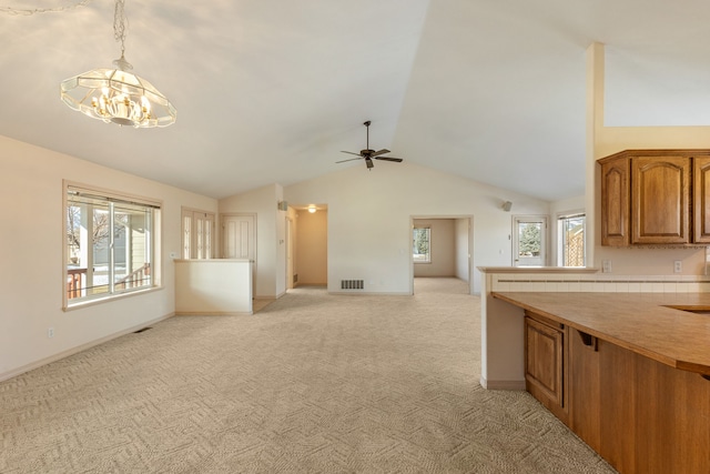 unfurnished living room with a notable chandelier, visible vents, light carpet, vaulted ceiling, and baseboards