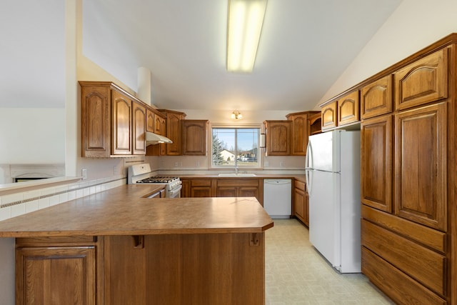 kitchen with lofted ceiling, under cabinet range hood, a peninsula, white appliances, and light floors