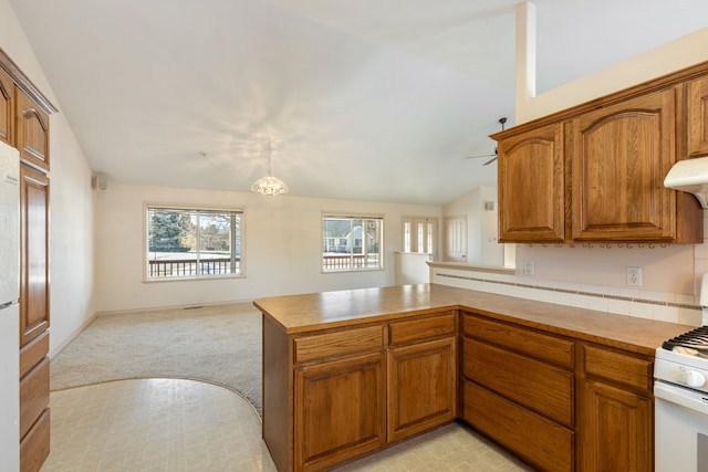 kitchen featuring open floor plan, white gas range, and brown cabinets