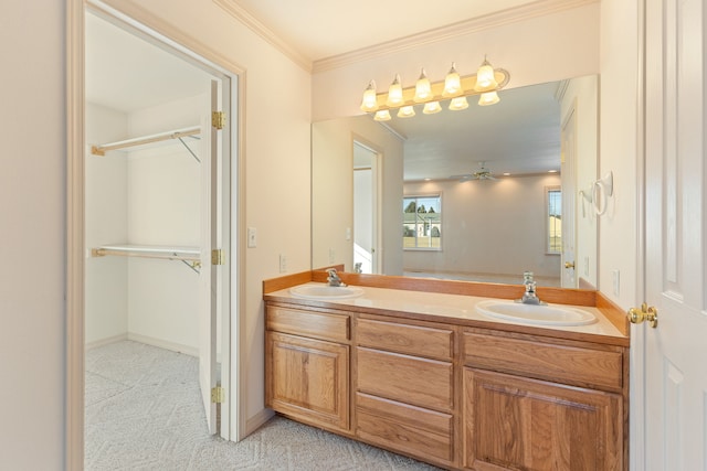 full bath with double vanity, crown molding, a spacious closet, and a sink