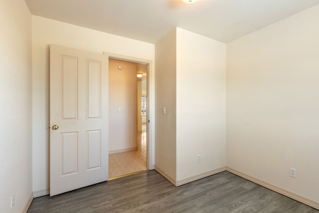 unfurnished room featuring wood finished floors and baseboards