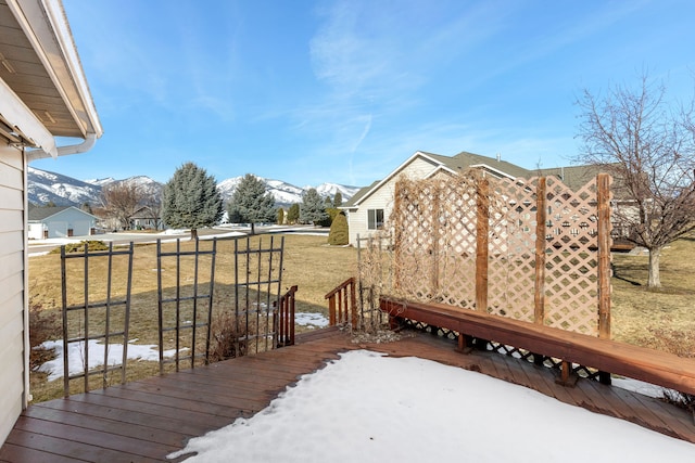 yard layered in snow with a deck with mountain view