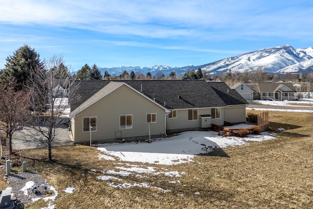 snow covered rear of property featuring a patio area and a mountain view