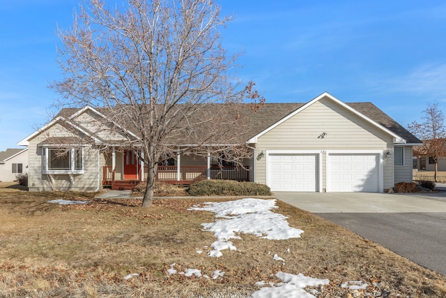 ranch-style home with an attached garage, aphalt driveway, and a porch