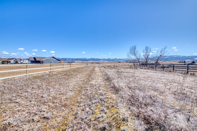 view of yard with a rural view and fence