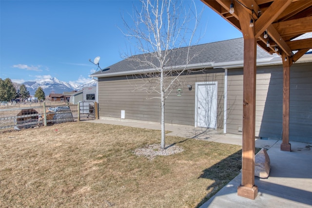 view of yard featuring a patio area, fence, and a mountain view