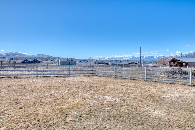 view of yard with a rural view, a mountain view, and fence