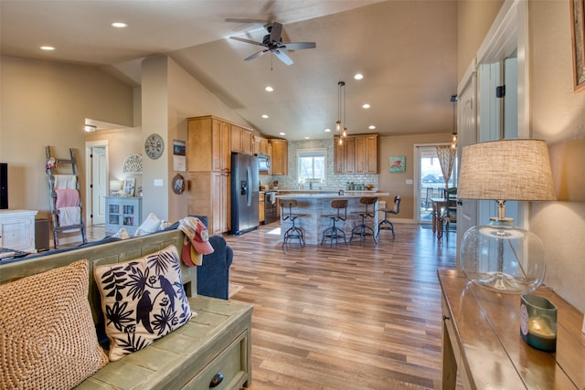 living area with light wood-style floors, plenty of natural light, ceiling fan, and recessed lighting