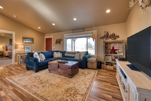 living area with lofted ceiling, recessed lighting, and wood finished floors