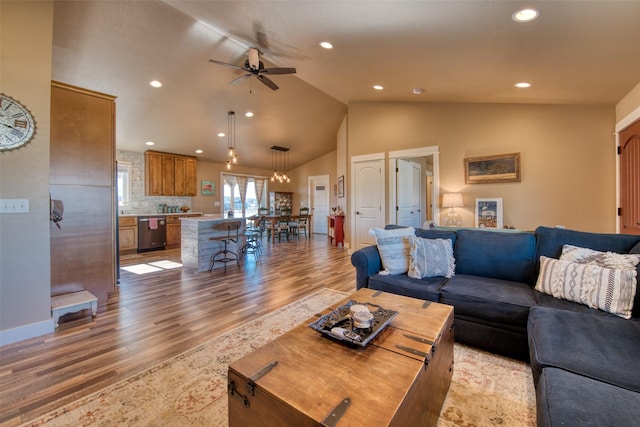 living room with lofted ceiling, recessed lighting, light wood-style flooring, a ceiling fan, and baseboards