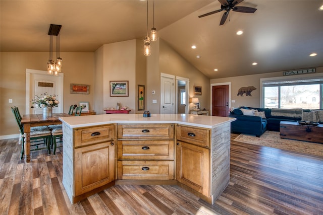 kitchen with a center island, pendant lighting, light countertops, dark wood-type flooring, and open floor plan