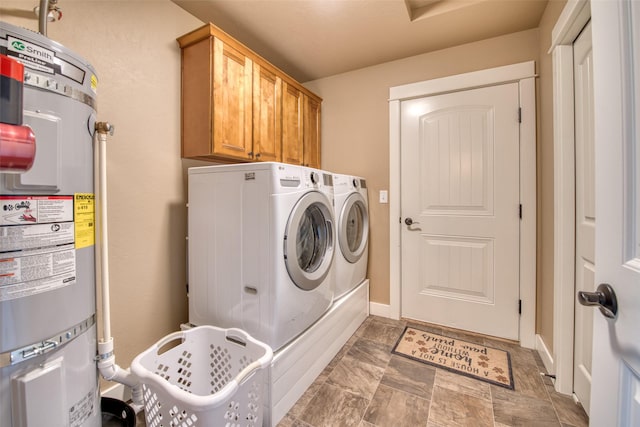 laundry area featuring cabinet space, baseboards, washer and clothes dryer, secured water heater, and stone finish flooring