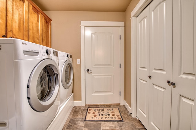 laundry room with cabinet space, baseboards, and separate washer and dryer