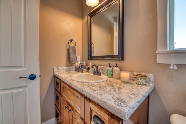 bathroom featuring a textured wall and vanity