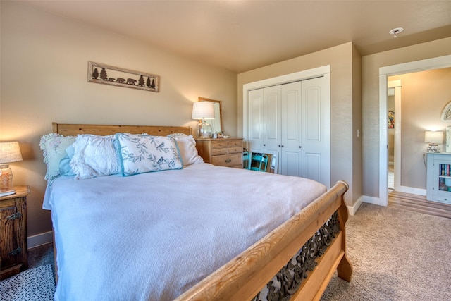 carpeted bedroom featuring baseboards and a closet