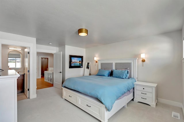 bedroom featuring visible vents, light carpet, and baseboards